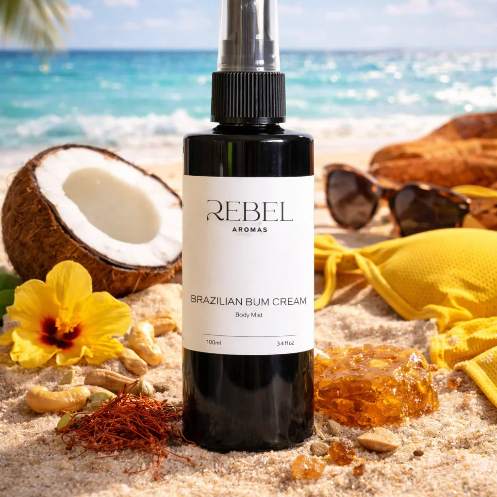 Bottle of Rebel Aromas Brazilian Bum Cream on a beach with coconut, flowers, and sunglasses.