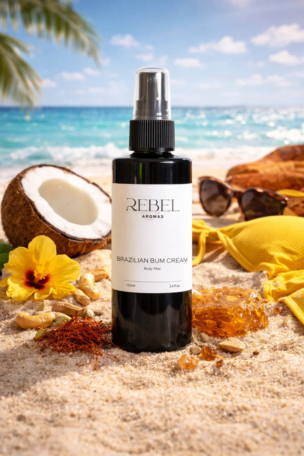 Bottle of Rebel Aromas Brazilian Bum Cream on a beach with coconut, flowers, and sunglasses.